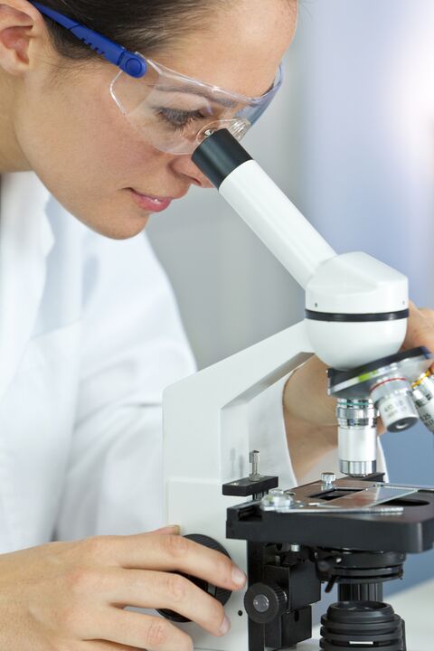 woman looking through a microscope